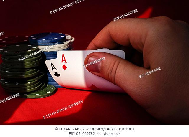 Two aces high on red table with chips on black background