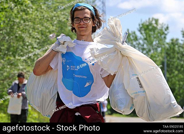 RUSSIA, ROSTOV REGION - MAY 12, 2023: A volunteer carries garbage bags in the village of Starocherkasskaya as part of the Waters of Russia All-Russian coastal...