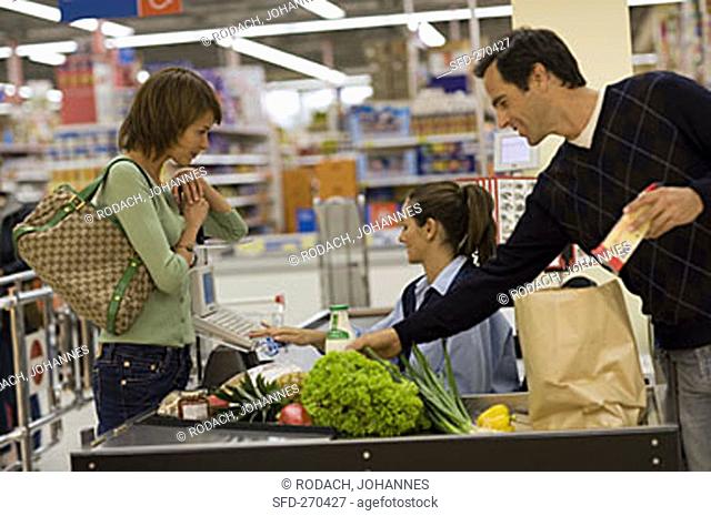 Young couple at the checkout in a supermarket