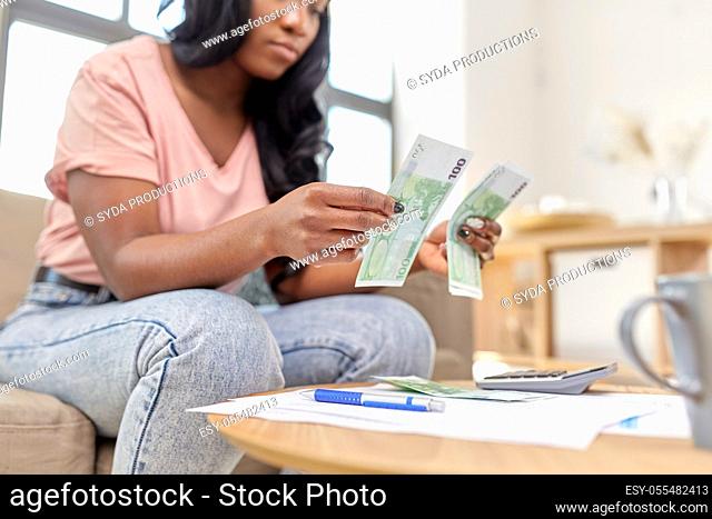 african american woman counting money at home