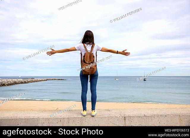 Woman with arms outstretched on wall