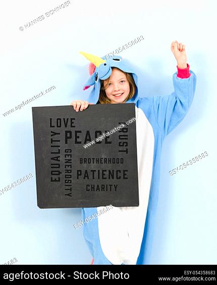 pretty blonde girl with cozy blue unicorn costume with blackboard with words on it written