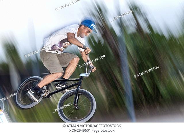young adult riding on bmx at a skate park