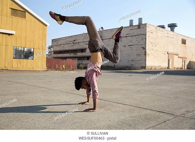 Young man doing a handstand outdoors