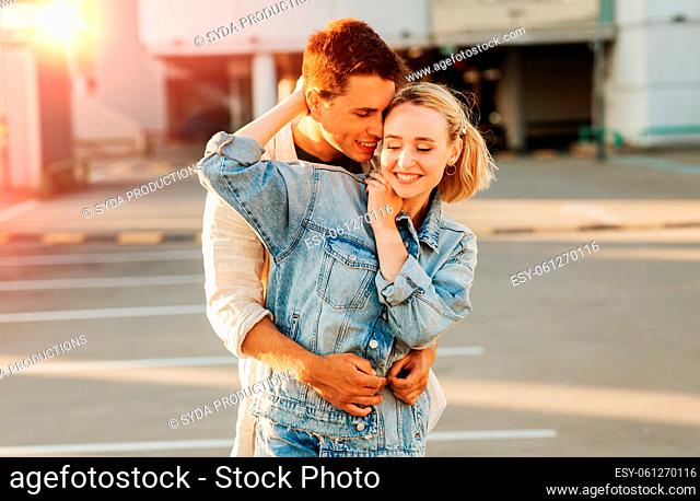 happy young couple hugging on city parking