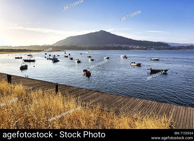 Wooden jetty and boats, mouth of the river Minho in the evening light, Caminha, Viana do Castelo, Portugal, Europe