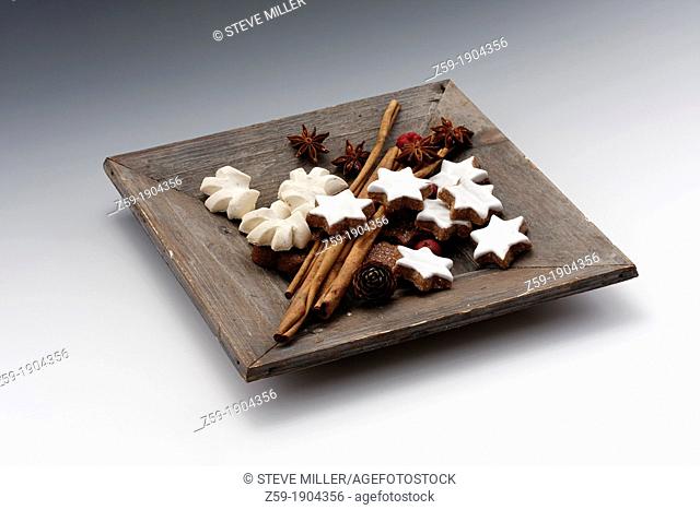 fruits of star anise - Illicium verum - cinnamon sticks in wooden bowl - Cinnamomum cassia - cinnamon star and anise flavoured cookies at christmas