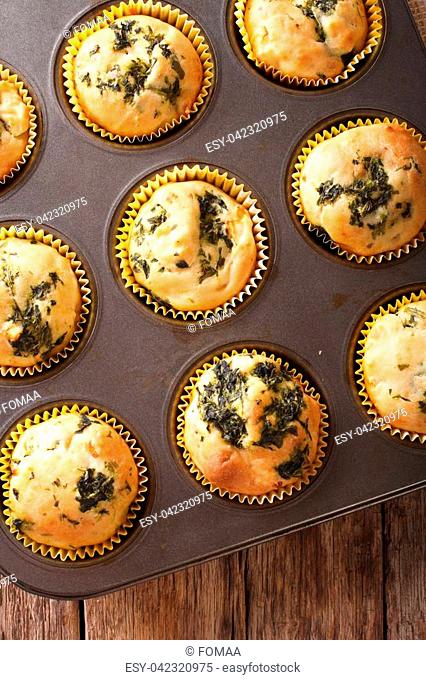muffins with fresh spinach and feta cheese close up in baking dish on the table. vertical view from above