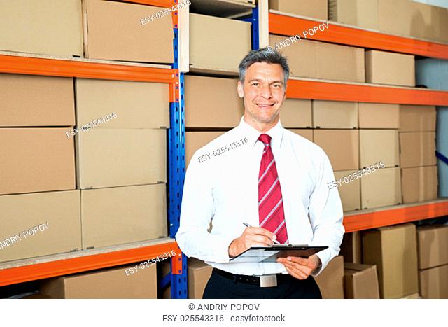 Happy Manager Writing On Clipboard In Distribution Warehouse