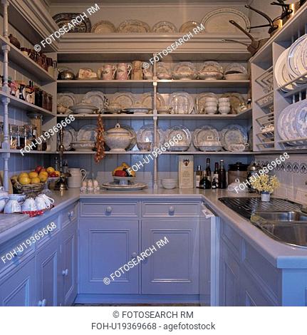 White and blue galley kitchen with china on open shelves