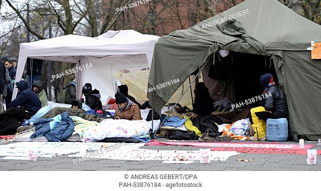 Refugees from various countries sit in front of their tent at the Sendlinger Tor in Munich, Germany, 26 November 2014. A group of refugees from various...
