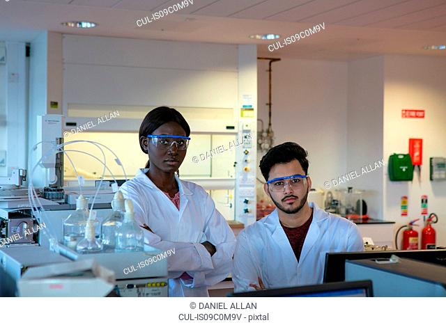 Young male and female scientists in laboratory, portrait