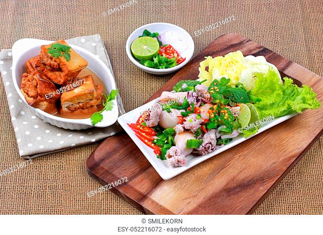 Gold bar soup as fried tofu wrap minced pork in soup served with spicy and sour mixed herb salad with squid wrap minced pork are Thai cuisine and sliced lemon...