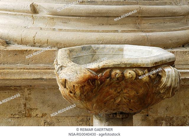 Worn marble of holy water font in San Fortunato church in Todi Italy