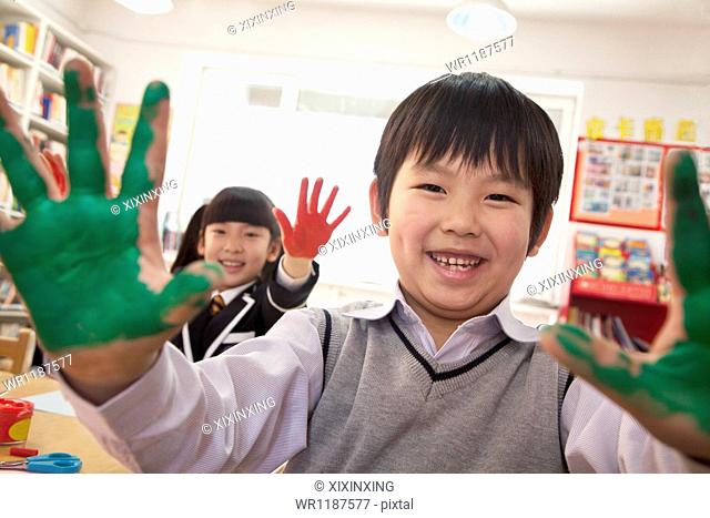 School children showing their hands covered in paint