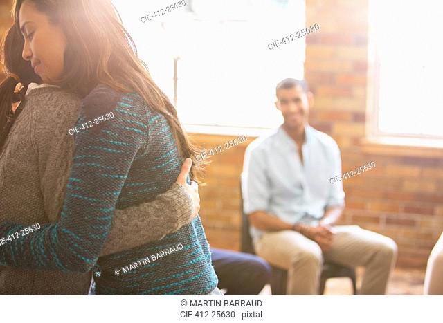 Women hugging at group therapy session