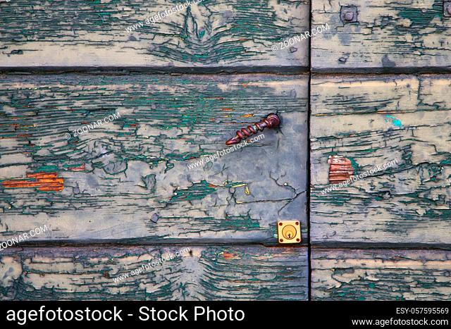 abstract sumirago cross  brass brown knocker in a  closed wood door  varese italy sunny day