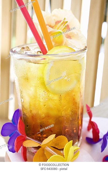Cuba Libre with slice of lemon and amaryllis flower