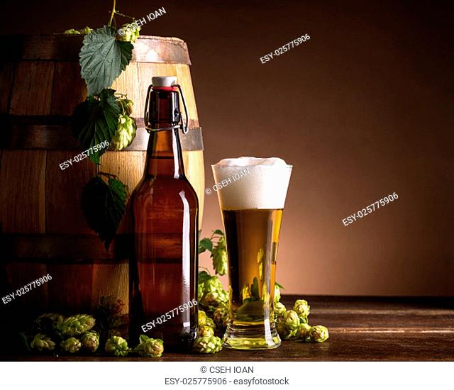 Beer glass and bottle with hops and barrel