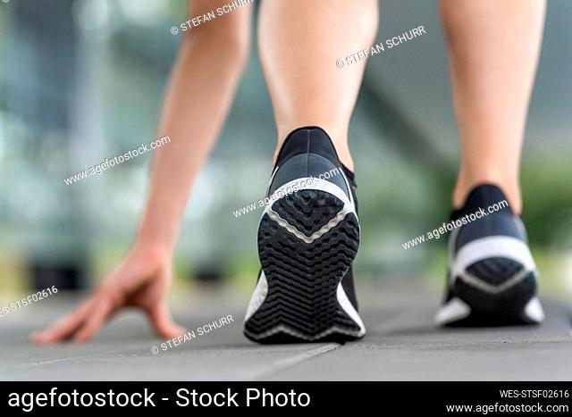 Legs of young woman exercising on footpath