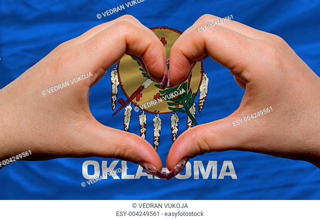 over american state flag of oklahoma showed heart and love gestu