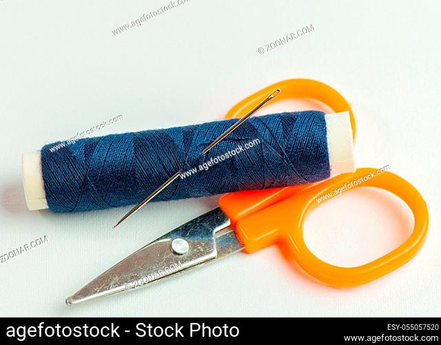 Nähgarnrollen in diversen Farben bei einer Schneiderei vor weißen Hintergrund Sewing thread rolls in various colors at a tailor shop against a white background