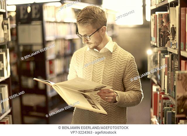 man browsing book, library, glasses, student, university, knowledge