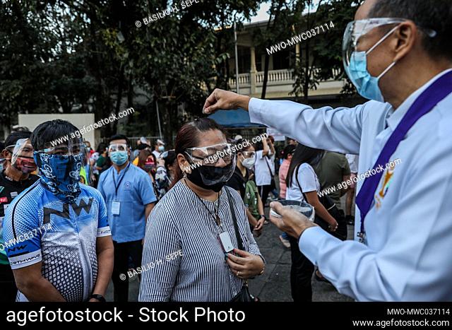 A lay minister sprinkles ash on the head of a Catholic devotee during an Ash Wednesday mass at the Redemptorist church in Baclaran, Metro Manila