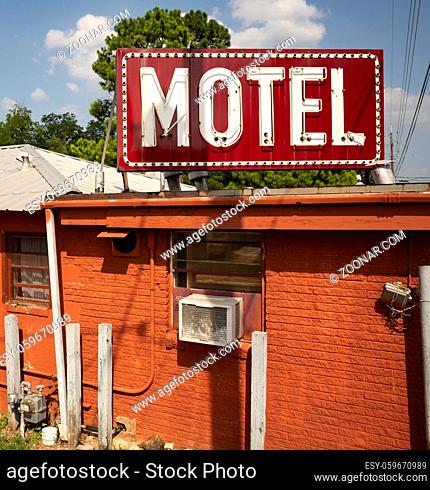 A saturated scene of blue skies behind an urban motel building and sign in Texarcana