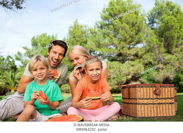 Happy family having a picnic and eating watermelon portrait