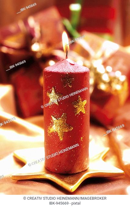 Red candle on a golden star-shaped candle holder