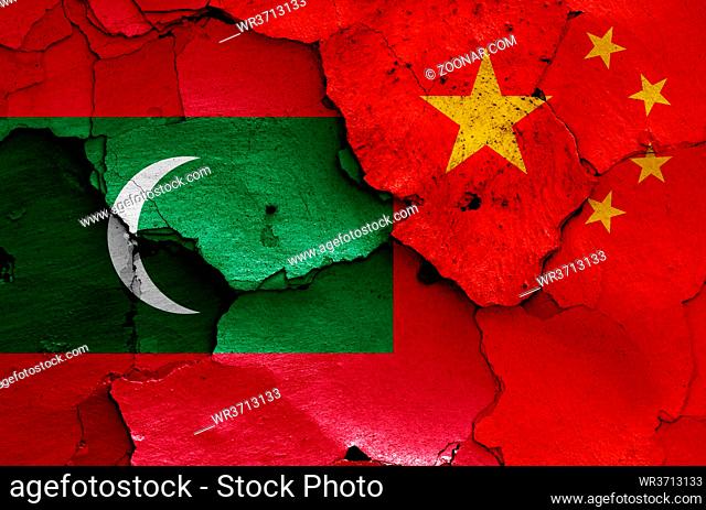 flags of Maldives and China painted on cracked wall