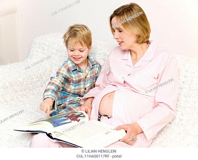 pregnant woman and boy reading book