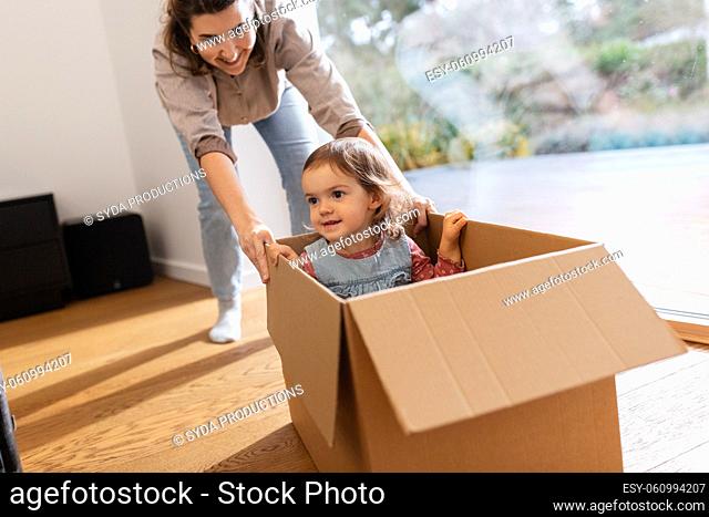 happy mother and daughter in box playing at home
