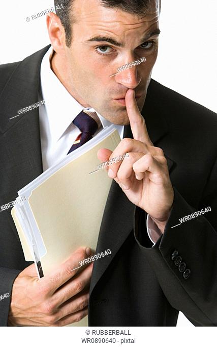 Portrait of a businessman hiding a file
