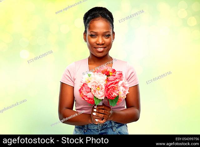 happy african american woman with bunch of flowers