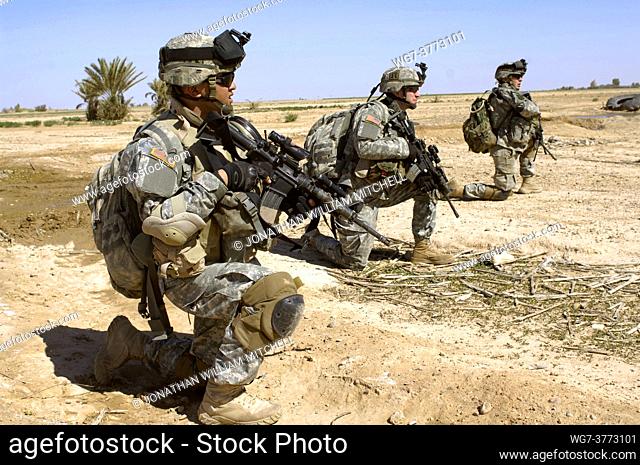 IRAQ Near Samarra -- 16 Mar 2006 -- US Army soldiers take a break as they advance through a field during Operation Swarmer in the Salah Ad Din province of Iraq