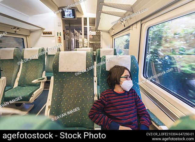 Young male tourist wearing mask travels by train