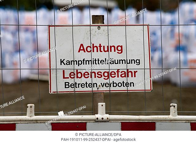 11 October 2019, Lower Saxony, Göttingen: A sign ""Attention, explosive ordnance clearance. Danger to life. Trespassing forbidden"" can be seen in front of...