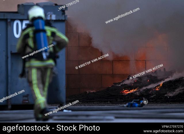 A fire fighter pictured at the site of IOK recycling and waste management company, in Beerse, Monday 28 March 2022. BELGA PHOTO KRISTOF VAN ACCOM
