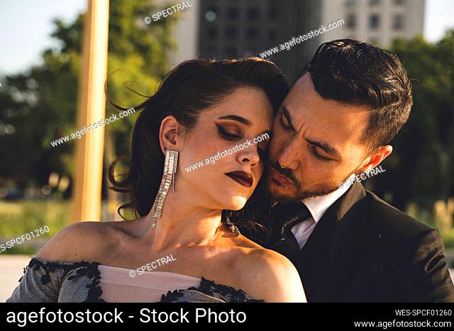 Male dancer with eyes closed embracing woman during summer