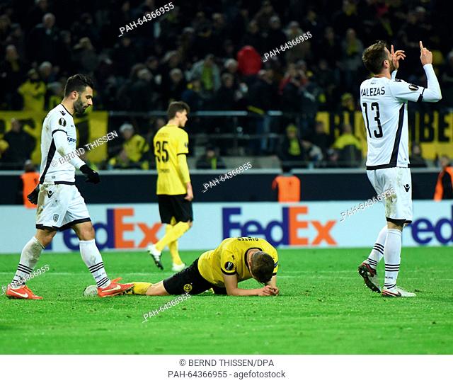 Dortmund's Matthias Ginter (C) lies on the pitch as Saloniki's Stelios Malezas (R) celebrates during the Europa League group C soccer match Borussia Dortmund vs...