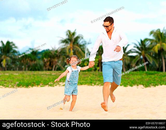 father's day. Dad and child daughter playing together outdoors on a summer beach