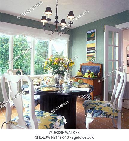 DINING ROOM - White Queen Anne chairs. Shiny black pedestal table, Roman shades, green walls with textured effects, white trim, floral arrangement