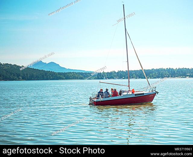 Doksy, Czechia 8th September 2020. Family in motorboat on Machovo lake with Bezdez castle on hill in background