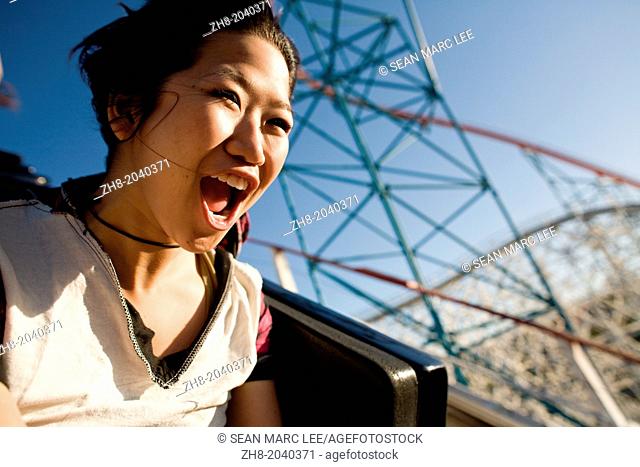 A young woman screams as she rides down a roller coaster in Southern California theme park