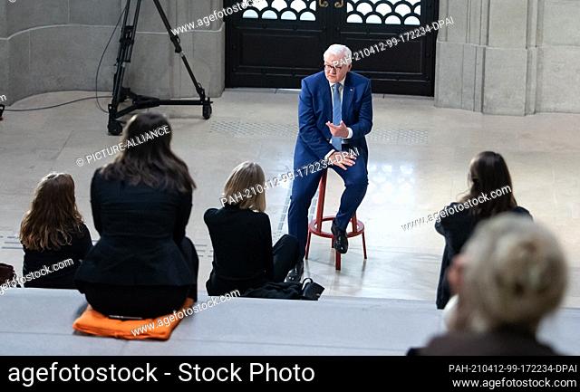 12 April 2021, Berlin: Federal President Frank-Walter Steinmeier chats with some students in a stairwell of the reopened Berlin State Library after his speech...
