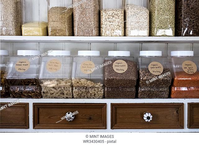 Close up of shelves with a selection of pasta, legumes and grains in glass jars