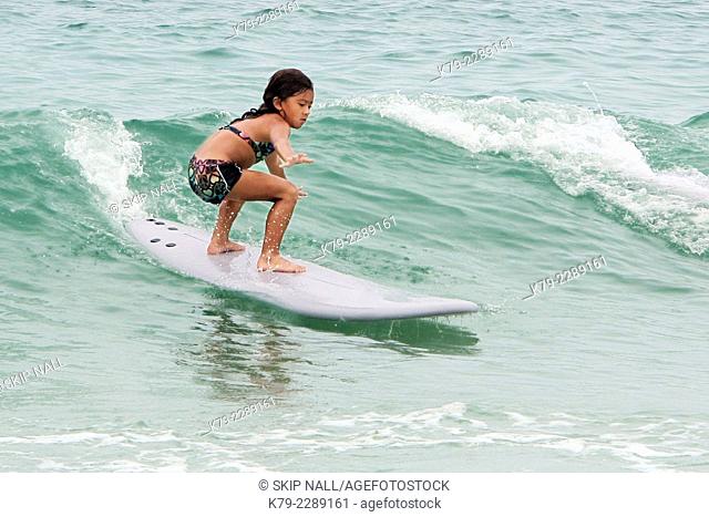 A six year old girl surfing