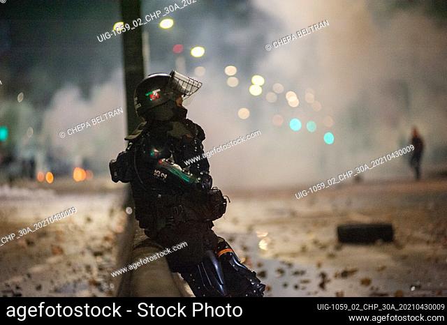 A riot police officer from ESMAD rests with a cloud of tear gas behind result of the clashes in Bogota, Colombia clashes happened soon after demonstrators tried...